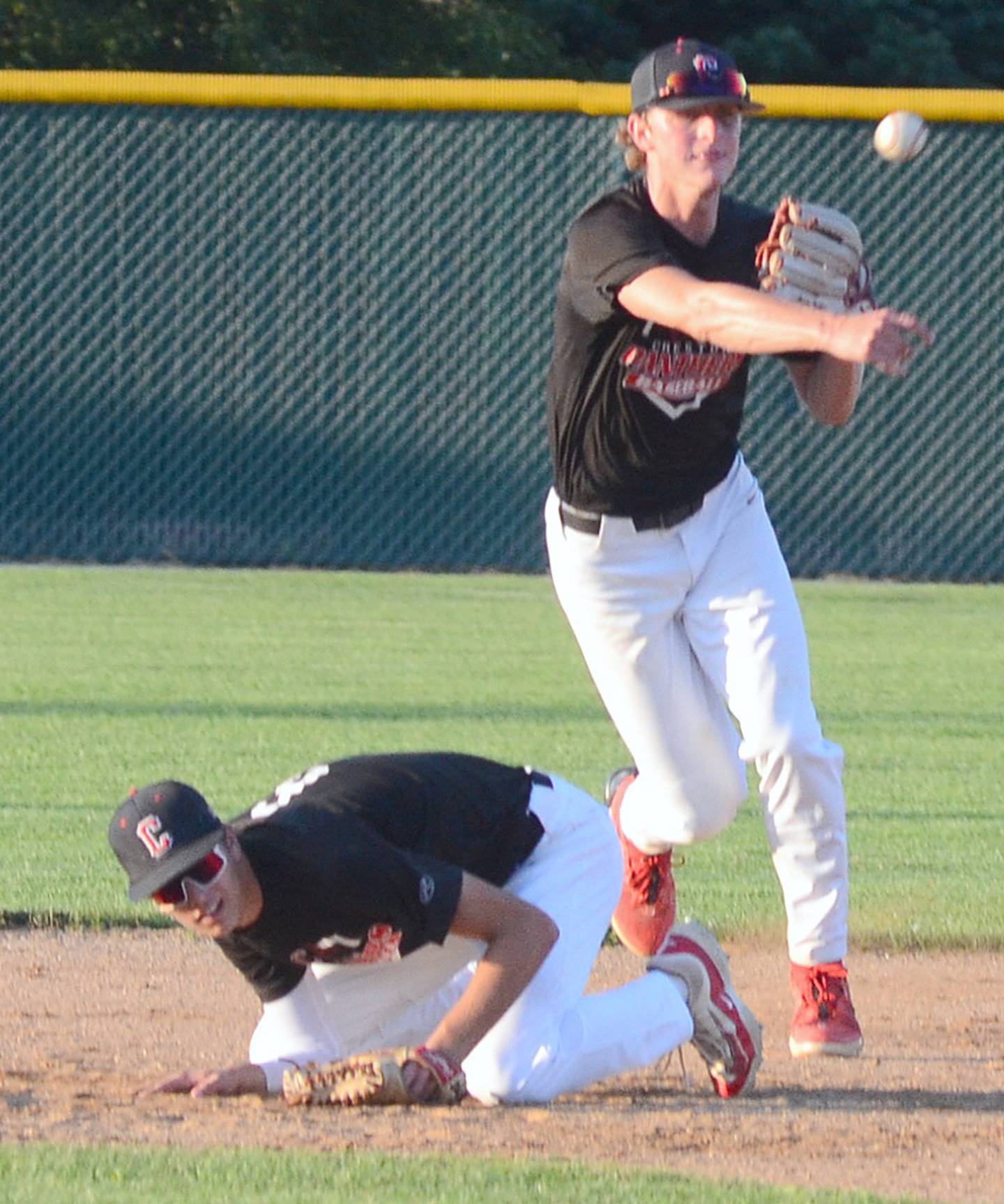 Second baseman Dylan Hoepker ducks as Creston shortstop Cael Turner throws to first base after fielding a grounder near the base during Monday's game against ADM. Turner was 1-of-2 at the plate with two runs scored in addition to pitching  2 2/3 innings of shutout relief of starter Parker Varner.