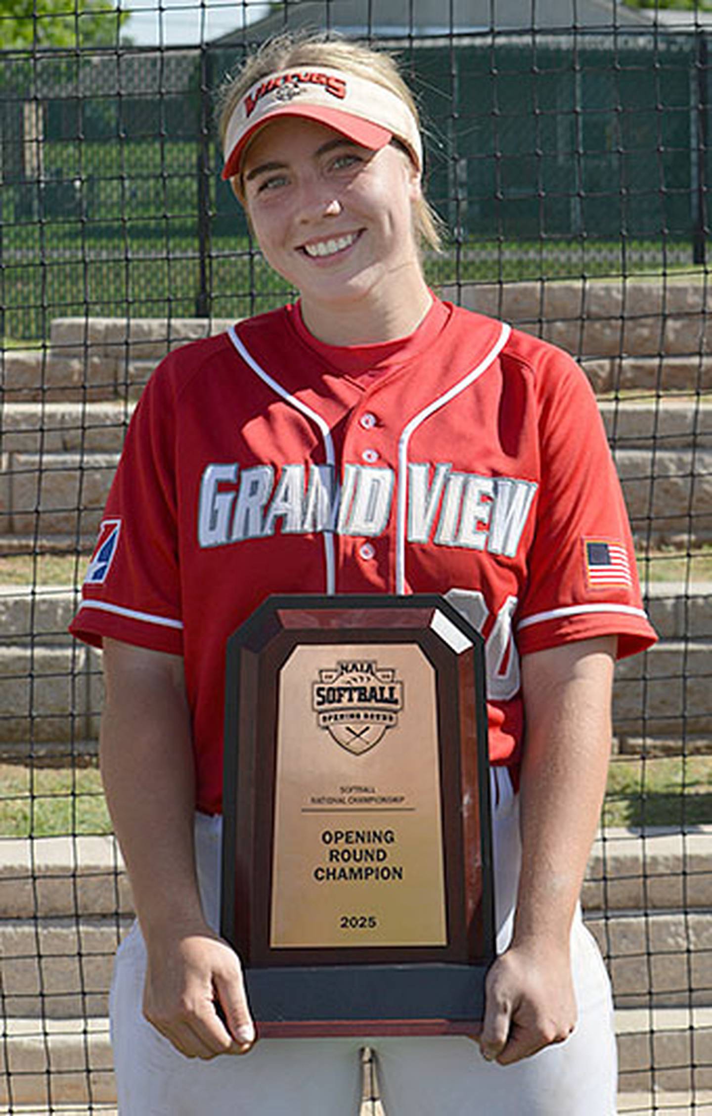 Grand View first baseman Nevaeh Randall holds the NAIA Opening Round championship trophy after the Vikings defeated nationally No. 1-ranked Science and Arts University in Chickasaw, Oklahoma.