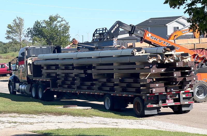 A lift unloads metal beams delivered for the Greenfield fire station project.