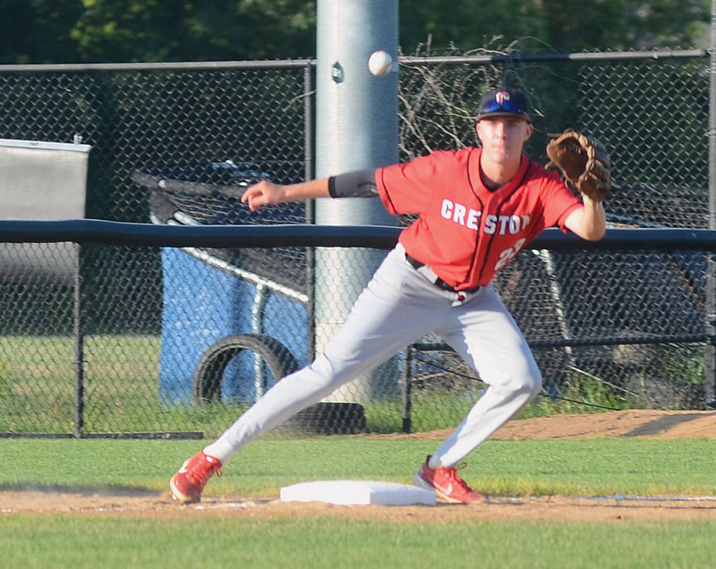 Creston third baseman Parker Varner receives a throw as a Van Meter baserunner tries to advance.