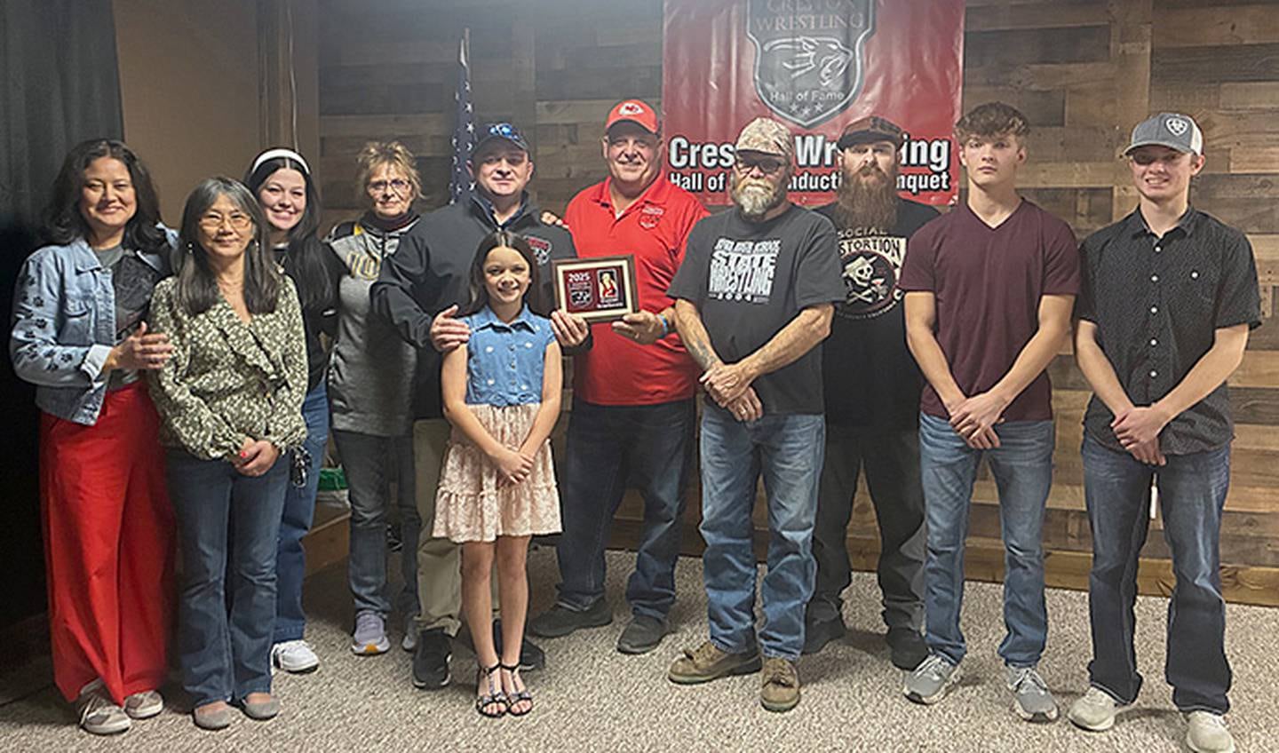 Committee member Chuck Hulett presents the Hall of Fame plaque to Daniel Scarberry, accompanied by his family.