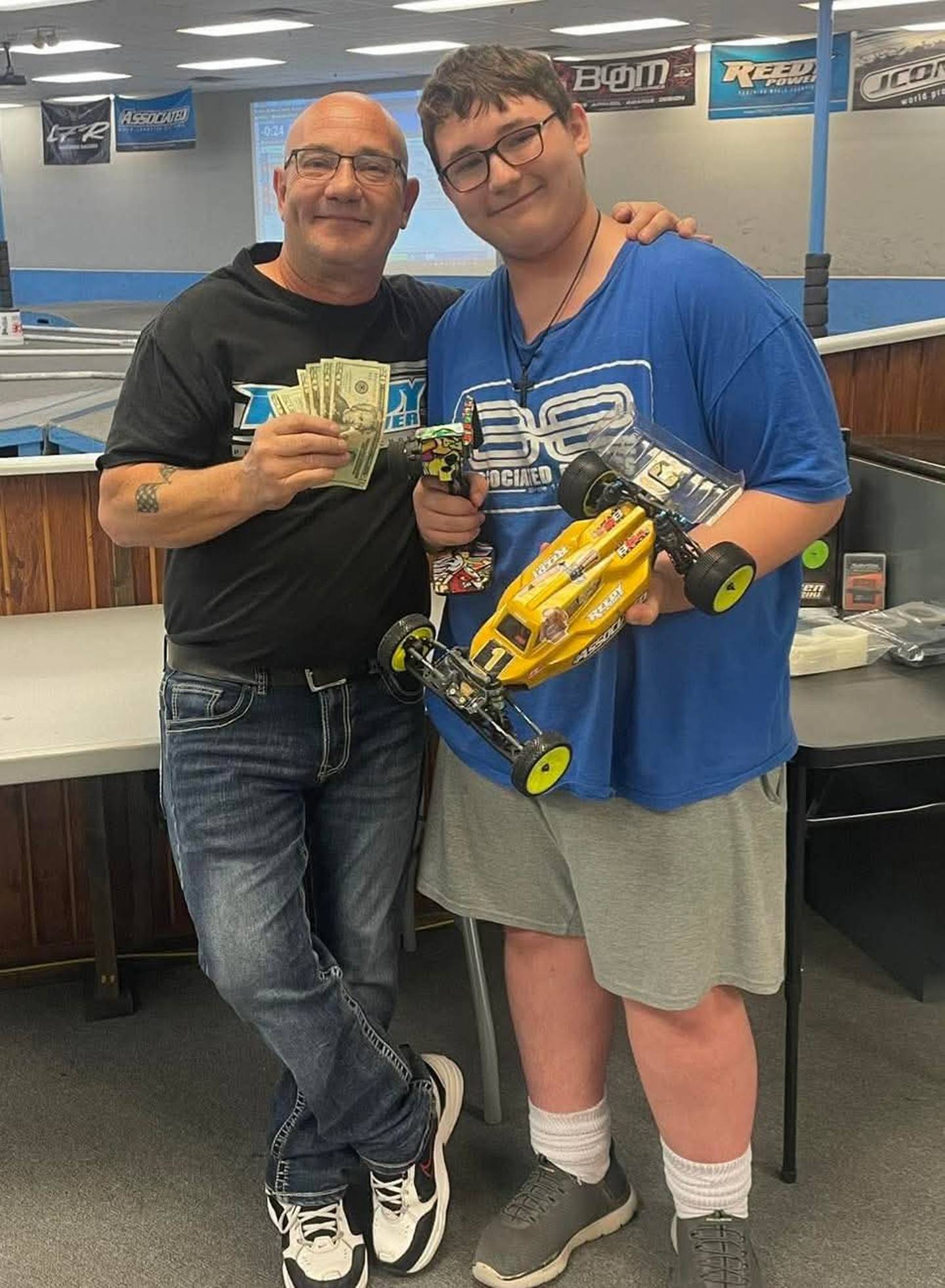 David Peavler, left, and son Jayme show their winnings after competing at a competition.