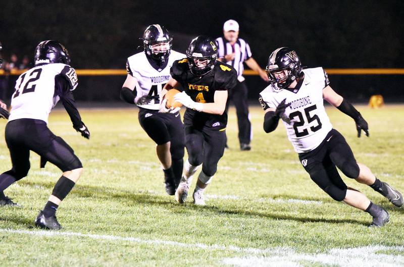 Dalton Kitzman of Lenox carries the ball through Woodbine defenders Friday at home in the first round of 8-man playoffs. Kitzman had a receiving touchdown in the 60-28 victory.
