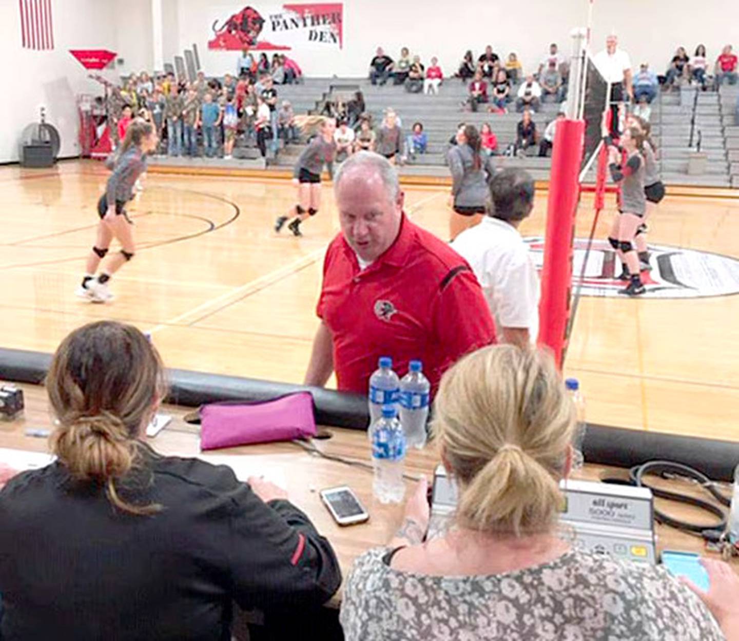 Retired Creston AD Jeff Bevins interacts with scorekeepers at a home volleyball game in 2018. Bevins is joining the Iowa High School Athletic Directors Association Hall of Fame in March 2025.