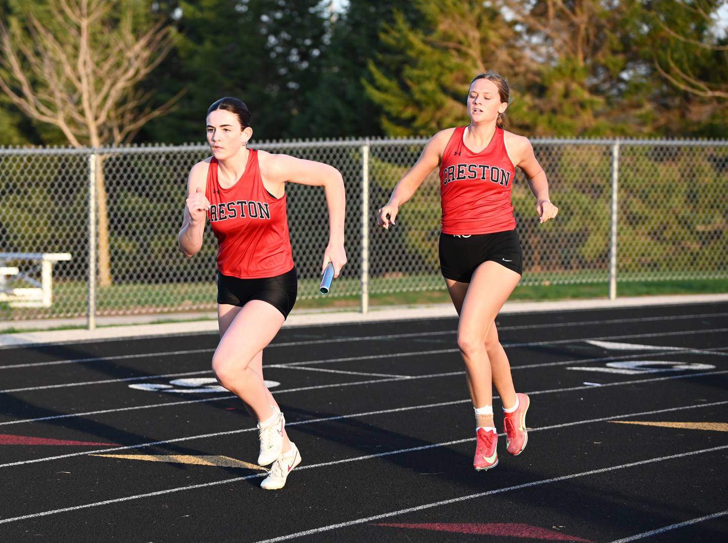 Kinzley Downing, left, takes off on the second leg of the 4x200m relay after Kadley Bailey, right, hands her the baton. The Panthers finished third in 1:58.73.