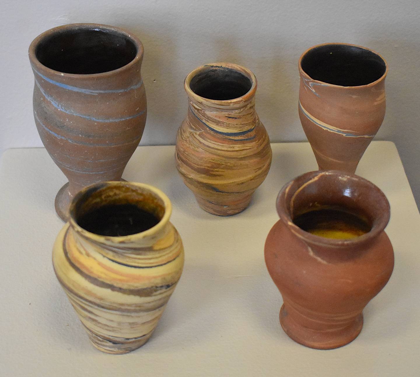 A collection of pottery with smooth edges and stained, curved lines.