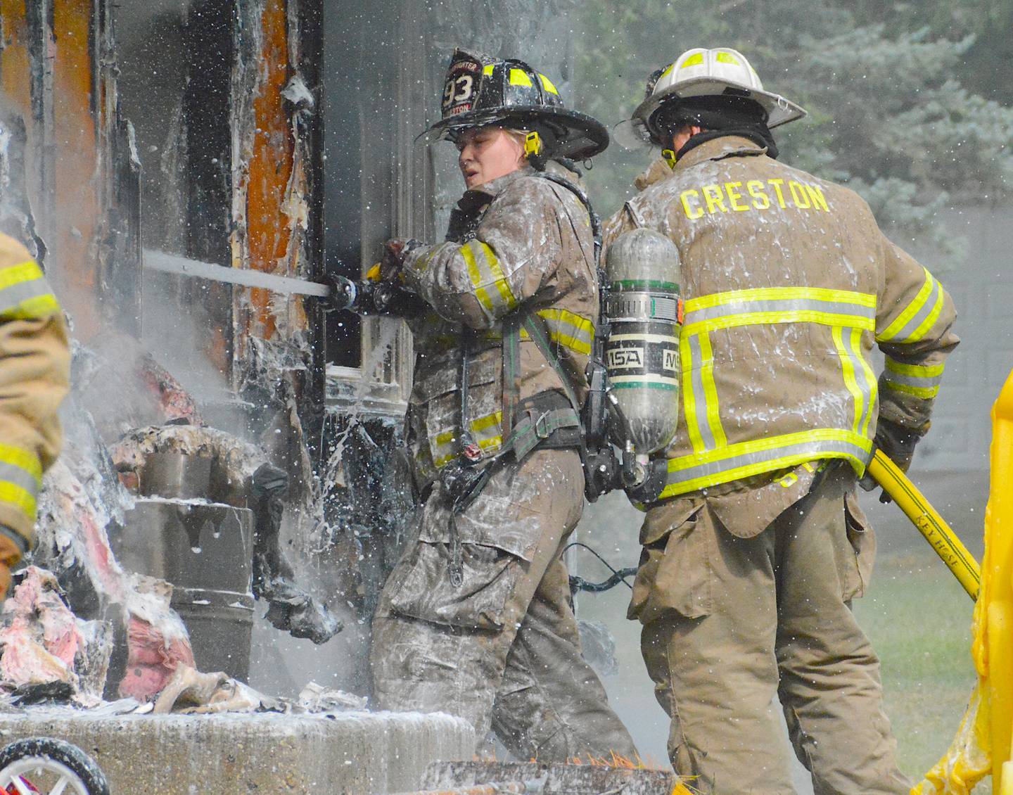 Firefighters work together to stop a blaze at a Creston home.