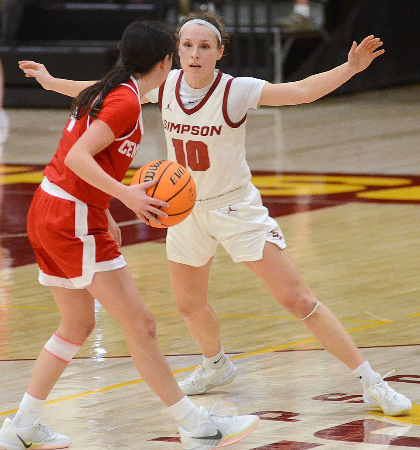Maddax DeVault of Simpson defends Central point guard Emily Naughton.