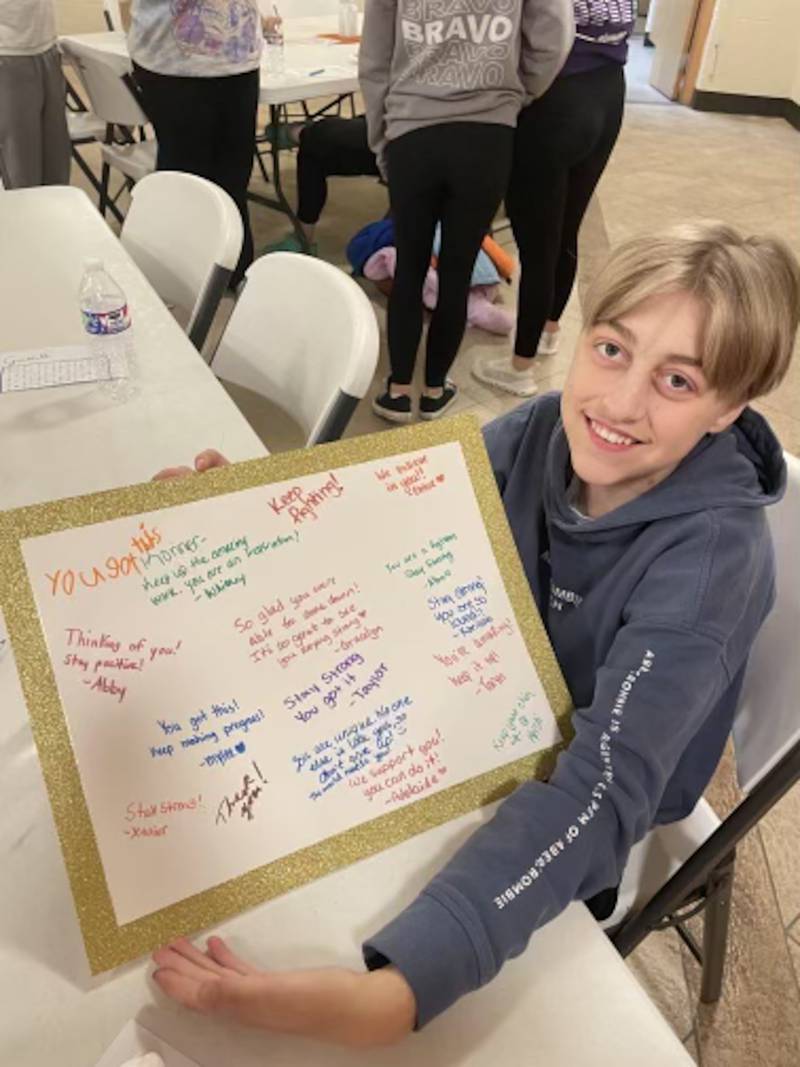 Konner Repp, 16, of Blaine, Minnesota, with a poster board of encouraging messages upon his visit to Greenfield.