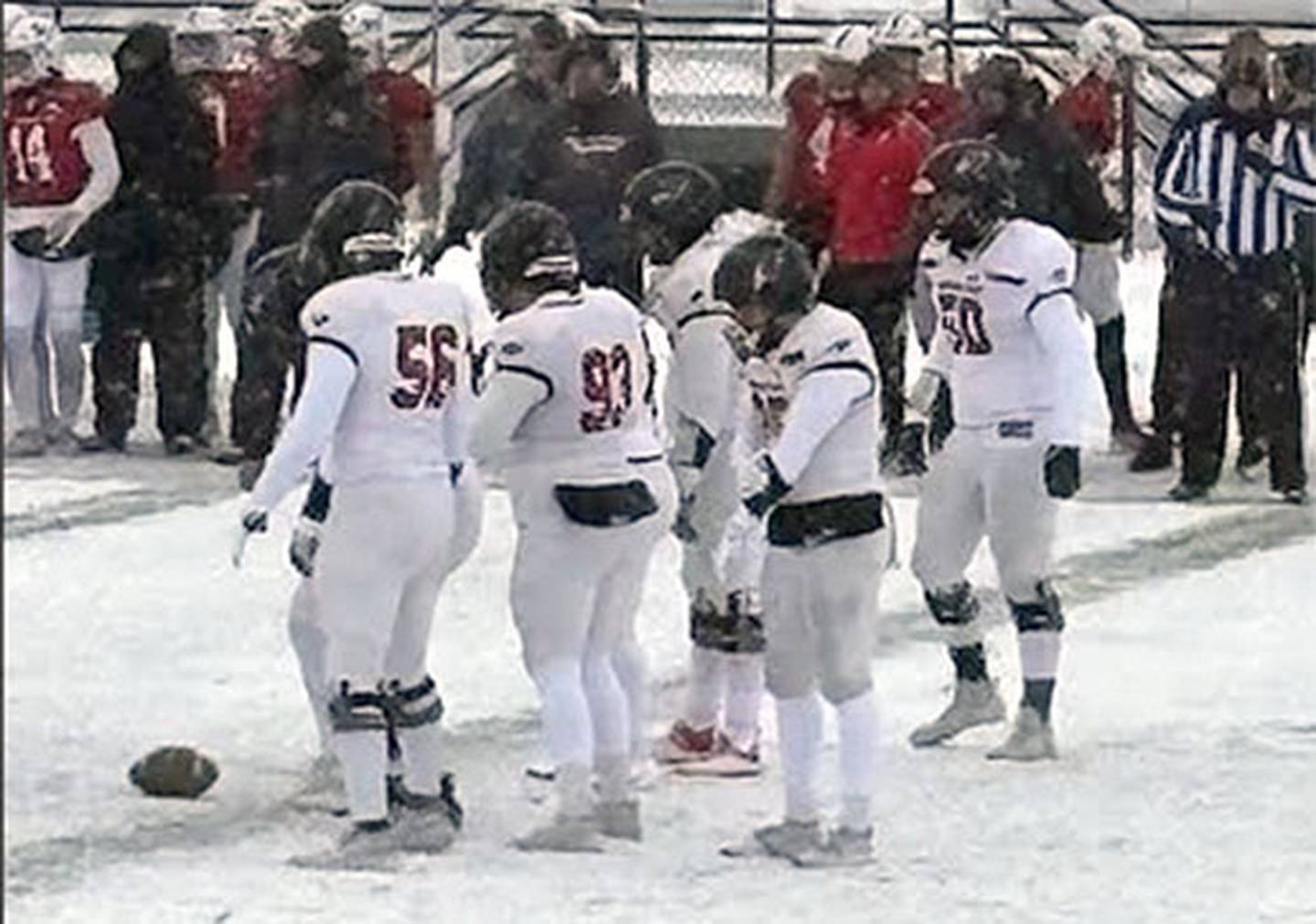 Avery Fuller (No. 50, right) lines up for a play on the snow-covered field in Des Moines for the NAIA semifinal game against Grand View.