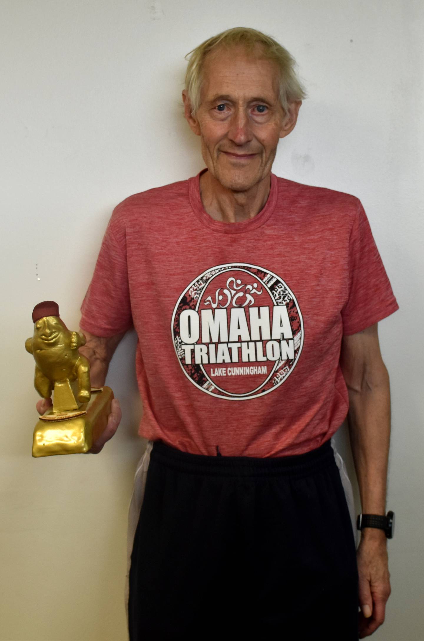 John Ytzen, 72, poses with his favorite of many trophies, this one a potato from the Antigo Tater Trot 10K in Wisconsin.