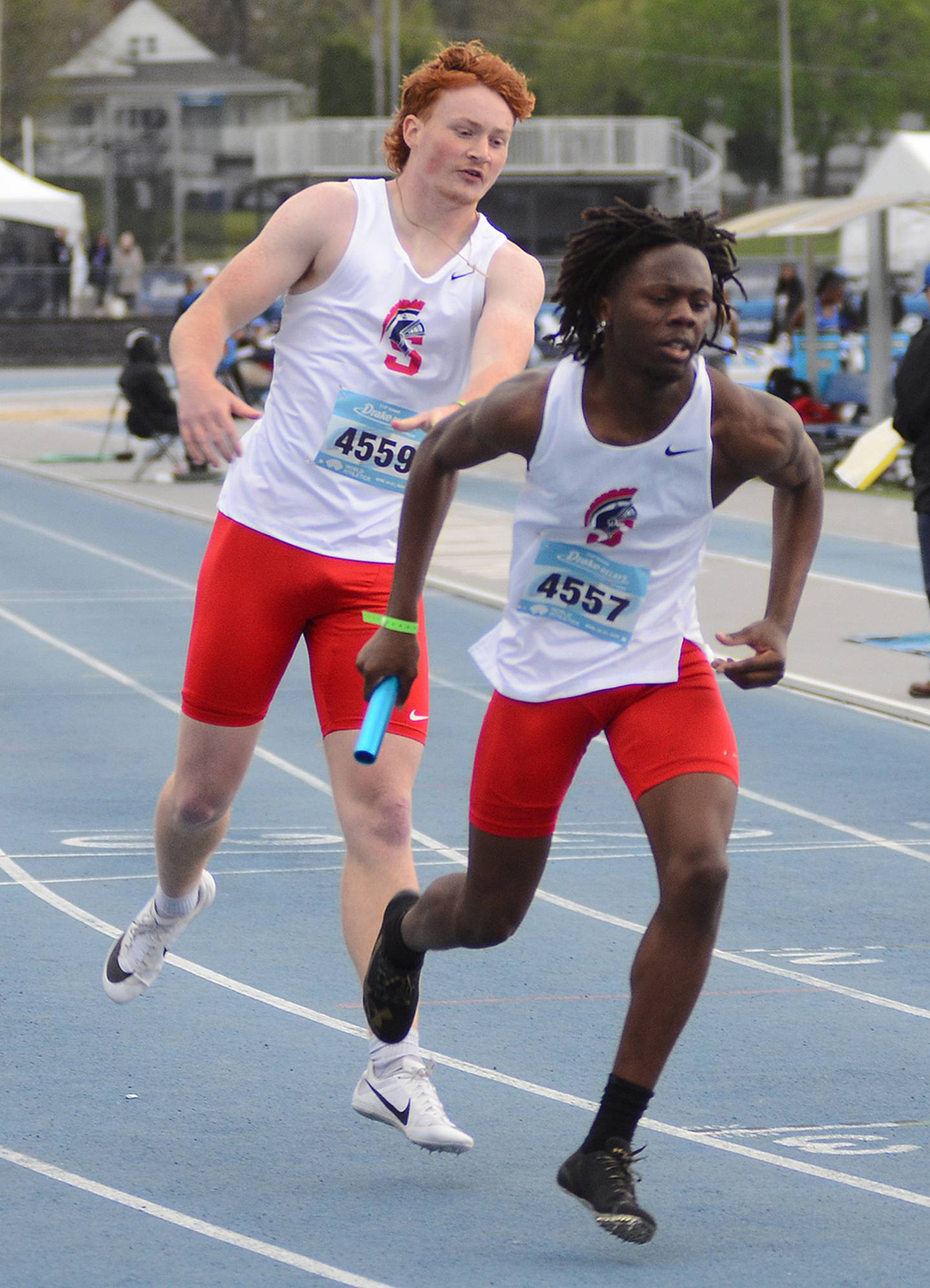 Southwestern's Rouce Sayee (right) begins his 400-meter portion of the sprint medley relay after getting the handoff from teammate Jedd Weinkoetz's 200-meter leg Friday at the Drake Relays.