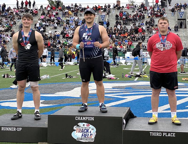 Morgan Cooley of East Union won the Class 1A shot put with a throw of 60-6.75. He is shown on the awards podium with runner-up Cal Heydon of Coon Rapids-Bayard (left) and third-place Braden Halverson of St. Ansgar.