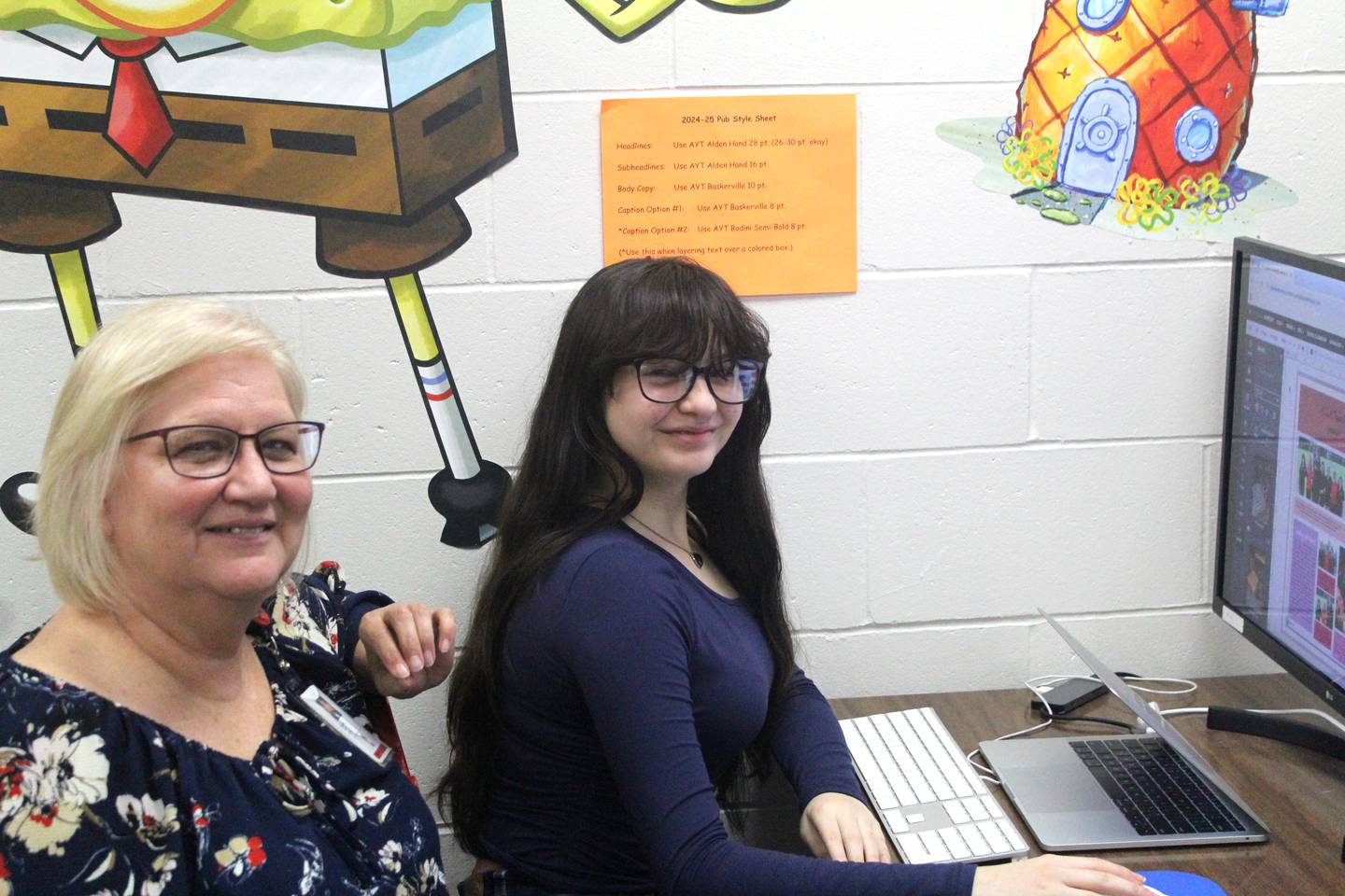 Peg Elben works with junior Kierra Hernandez on the CHS yearbook.