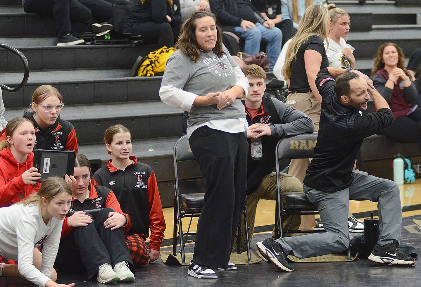 Creston coaches Maggie Arnold and Mario Galanakis give instructions to Alainah Galanakis during the second-place wrestleback match at 130 pounds. Galanakis won by technical fall.