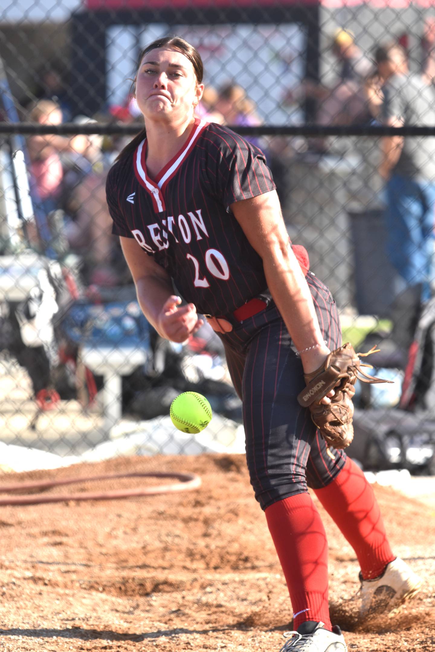 Kennedy Strider practices her pitch in the bullpen between innings. Strider pitched during the second game against Kuemper Catholic.