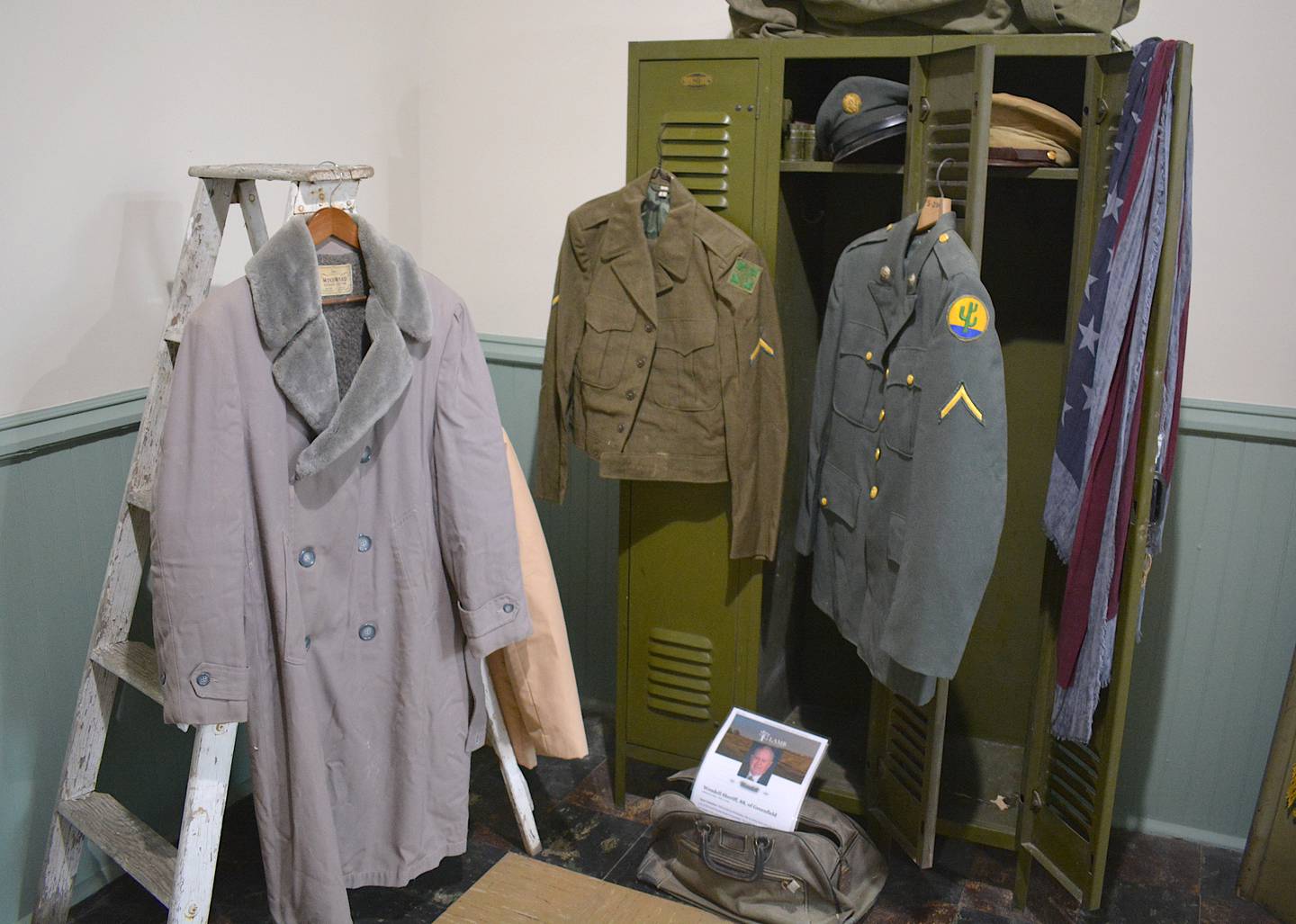 Uniforms and other military memorabilia found in the military room exhibit. An obituary for veteran Wendell Sheriff can be found.