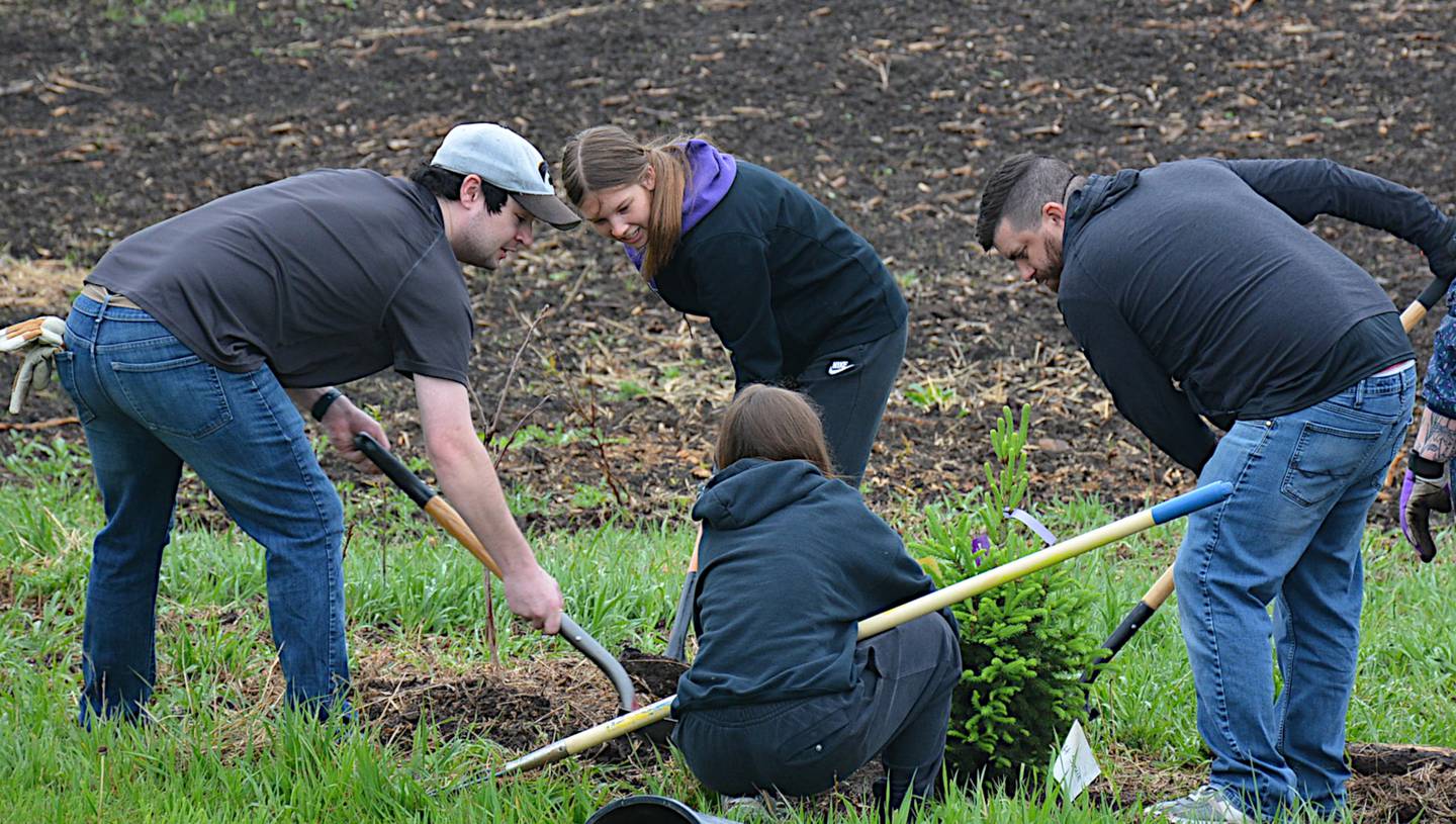 Volunteers plant a tree at Lake Greenfield May 1.