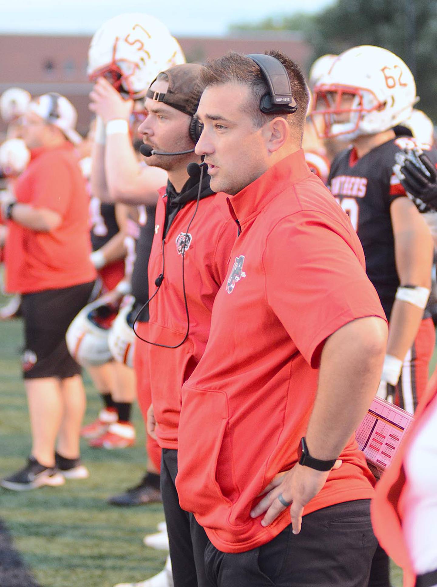 Offensive coordinator Garrison Carter (front) and quarterbacks coach Brandon Phipps watch the offense during Friday's game against Harlan.