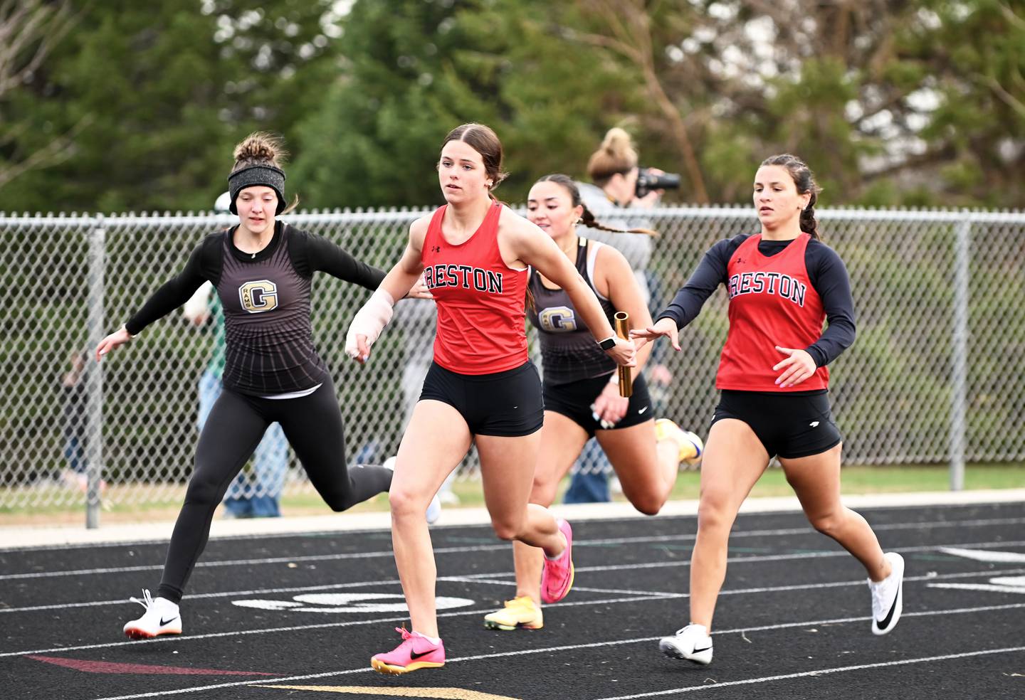 Creston senior Grace Keeler hands the baton to senior Braylee Pokorny after the first leg of the distance medley relay. The team, also consisting of Henley Shinn and Maylee Riley, won the race in 4:43.22.