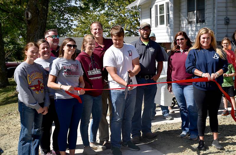 Members of Diagonal's school, development group and Ringgold County watch EJ Allee cut the ribbon Wednesday celebrating the town's new sidewalk project.
