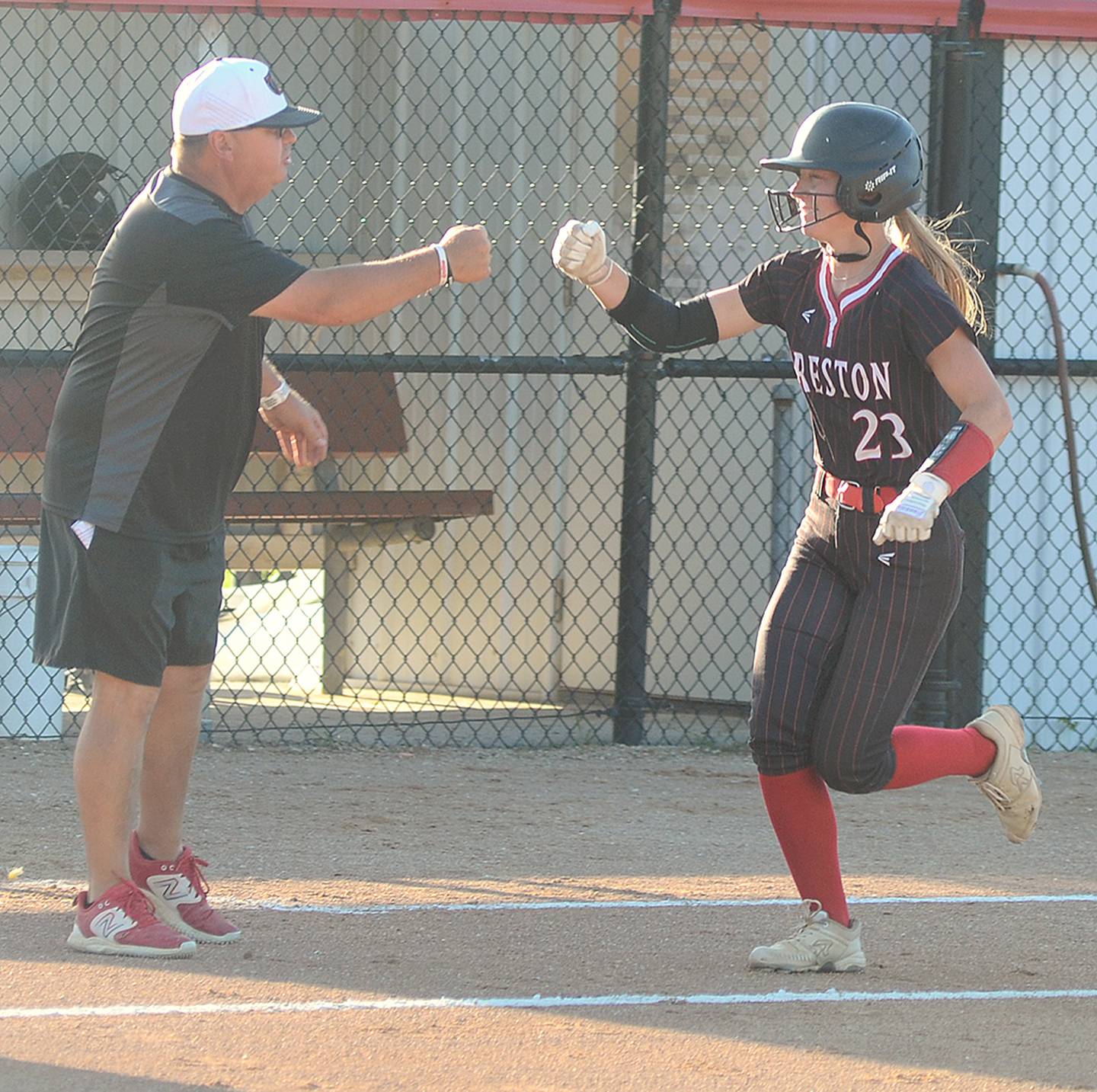 Creston coach Dave Hartman congratulates Avery Staver as she rounds third base after hitting her 12th home run of the season Monday against St. Albert. The Panther second baseman had four hits and drove in three runs in the doubleheader sweep.