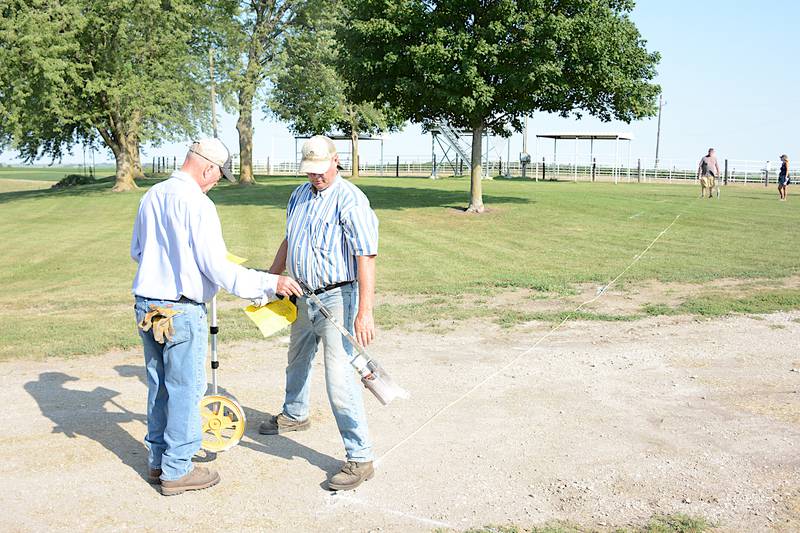 Greenfield Swap Meet volunteers Ted Wallace and Alvin Havens examine the map Friday morning on the Adair County Fairgrounds for placing lines that will outline vendor plots for the 2023 swap meet, which begins at sunrise Friday. There are over 1,200 vendor plots available.