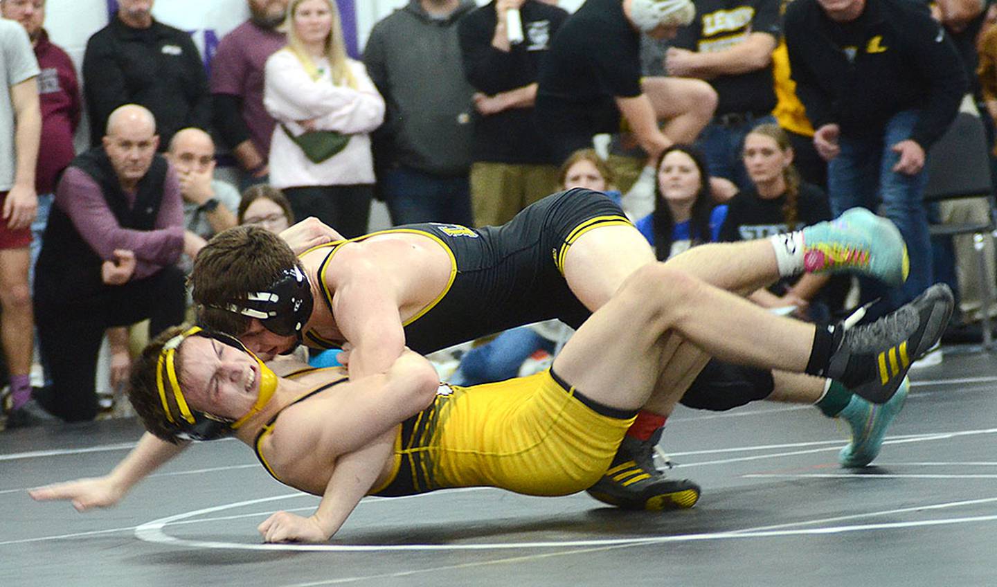 Dylan Stein of Lenox (top) and Winterset's Jax Jensen are airborne during one of Stein's takedowns in his 7-3 championship victory at 150 pounds.