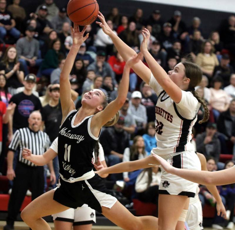 Wolverine freshman Abby Nelson glides to the hoop with resistance from behind from Mount Ayr's Izzy Gilbertson, last Tuesday night on the Raiderettes' home court. The now 14th-ranked Wolverines escaped with a 73-71 win against  15th-ranked Mount Ayr.