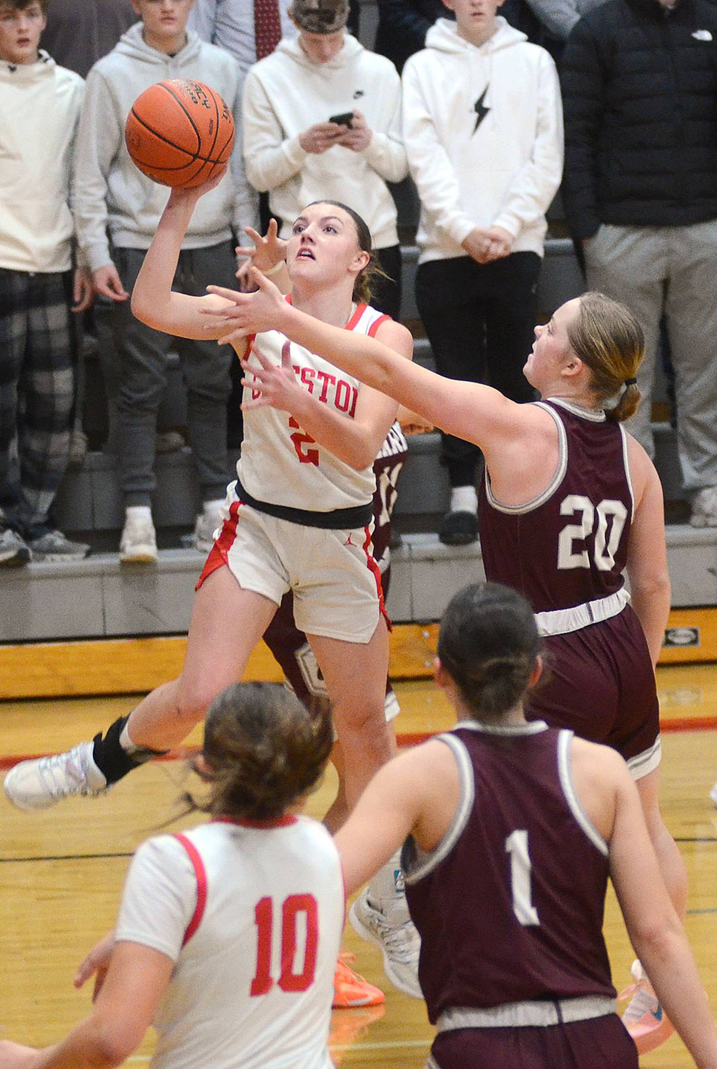 Hollynn Rieck of Creston drives past Clarke's Miah Graves (20) for a fast break layup. Rieck had 10 points, five rebounds, four steals and three assists in the senior night victory.