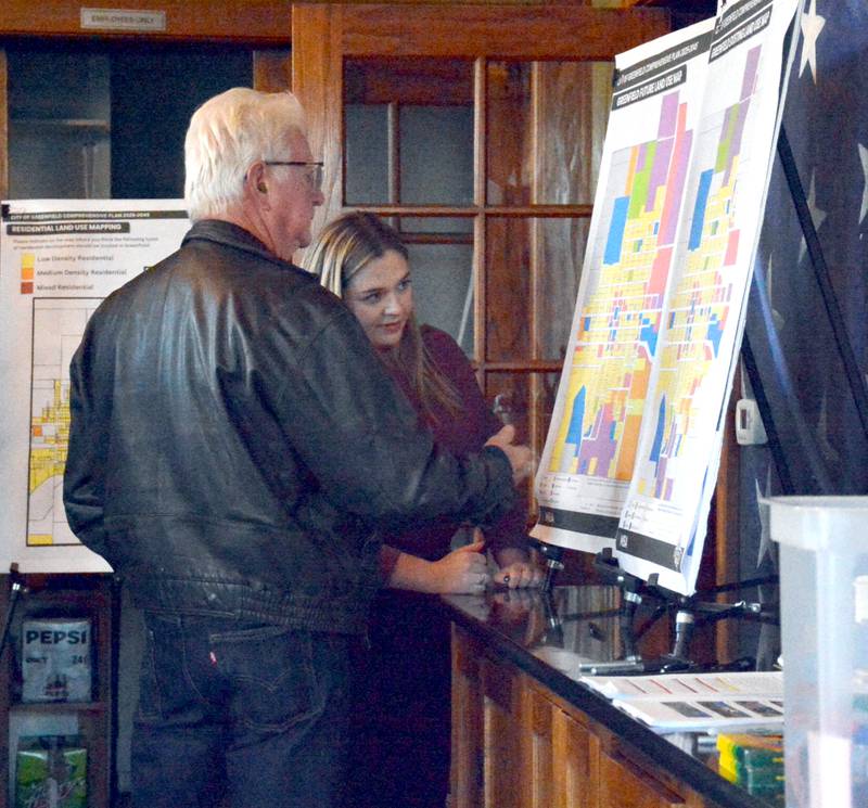 MSA Professional Services Assistant Planner Jenna Gilliam shows Greg Schildberg of Greenfield maps being developed as part of the comprehensive planning process.