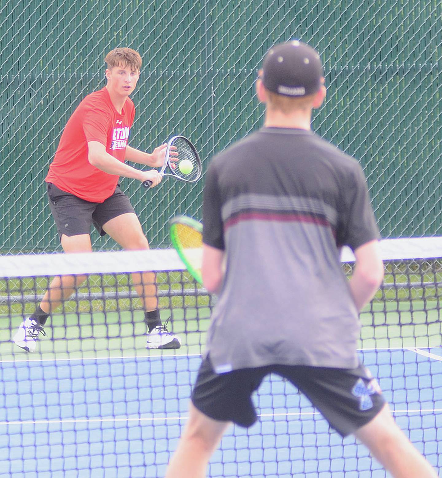 C.T. Stalker of Creston hits a backhand return during No. 1 doubles action Friday at Clarke. Stalker was one of two singles winners for the Panthers, prevailing 8-3 at No. 5 singles.