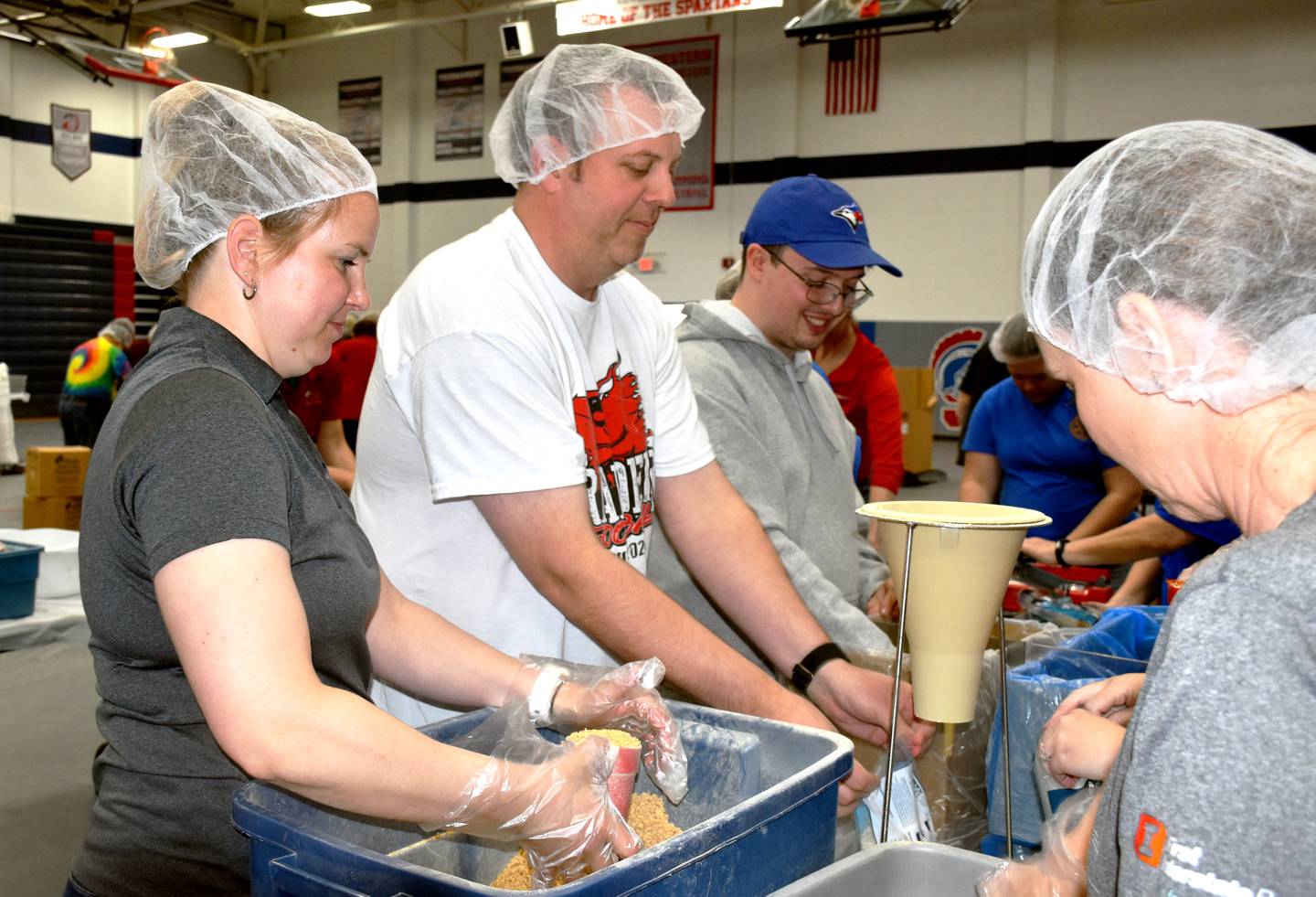 From left, Maggie McGehee, Jeff Levine and Nick Pauly scoop meals as a part of the Kiwanis/Rotary clubs team.