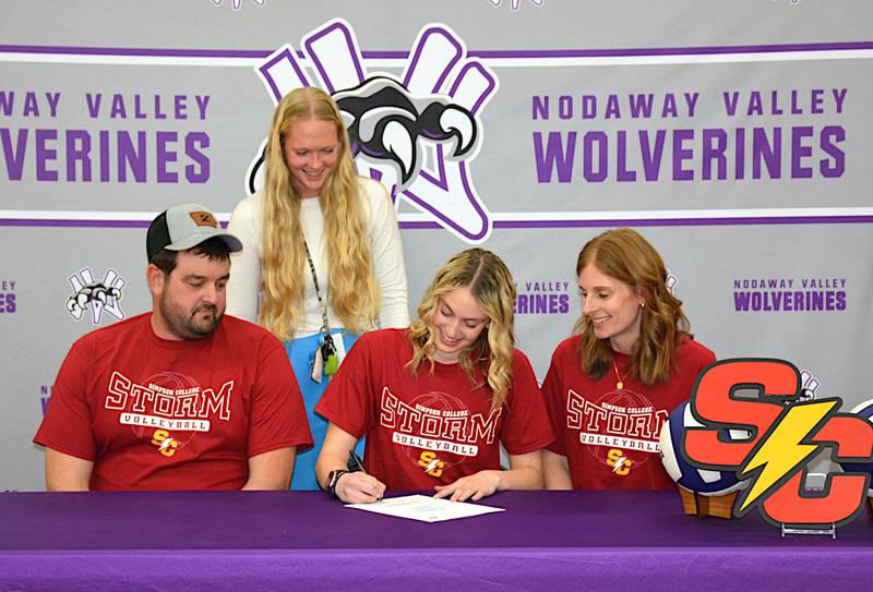 Surrounded by parents Kyle and Lisa Carstens and Nodaway Valley assistant volleyball coach Courtney Woodcock, Bailey Carstens signs to play volleyball for Simpson College.