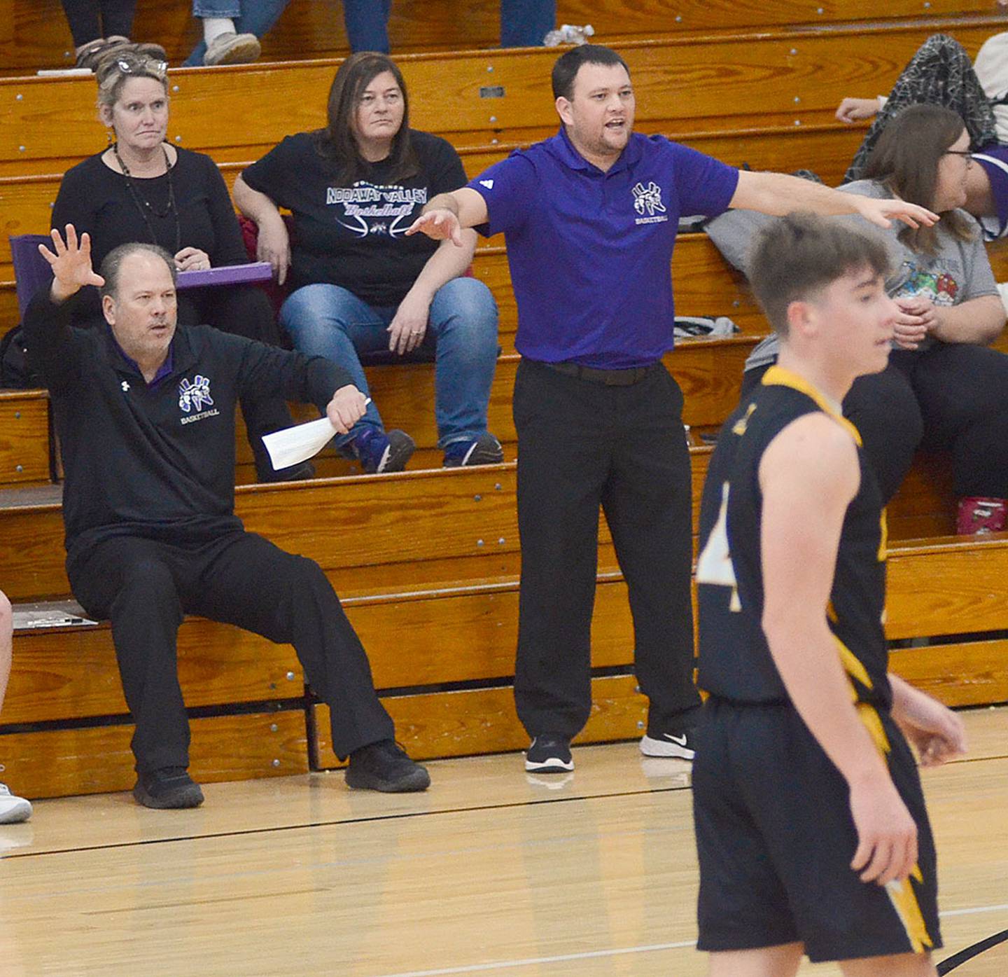 Nodaway Valley boys basketball coach Thad Tussey (standing) and volunteer assistant Steve Tussey (seated) shout instructions to Wolverine players during Tuesday's game against Lenox.
