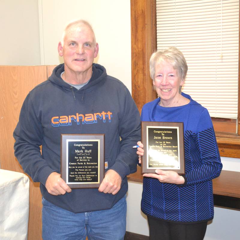 Mark Huff (left) and Jane Brown receive plaques thanking them for 33 and 32 years of service, respectively.