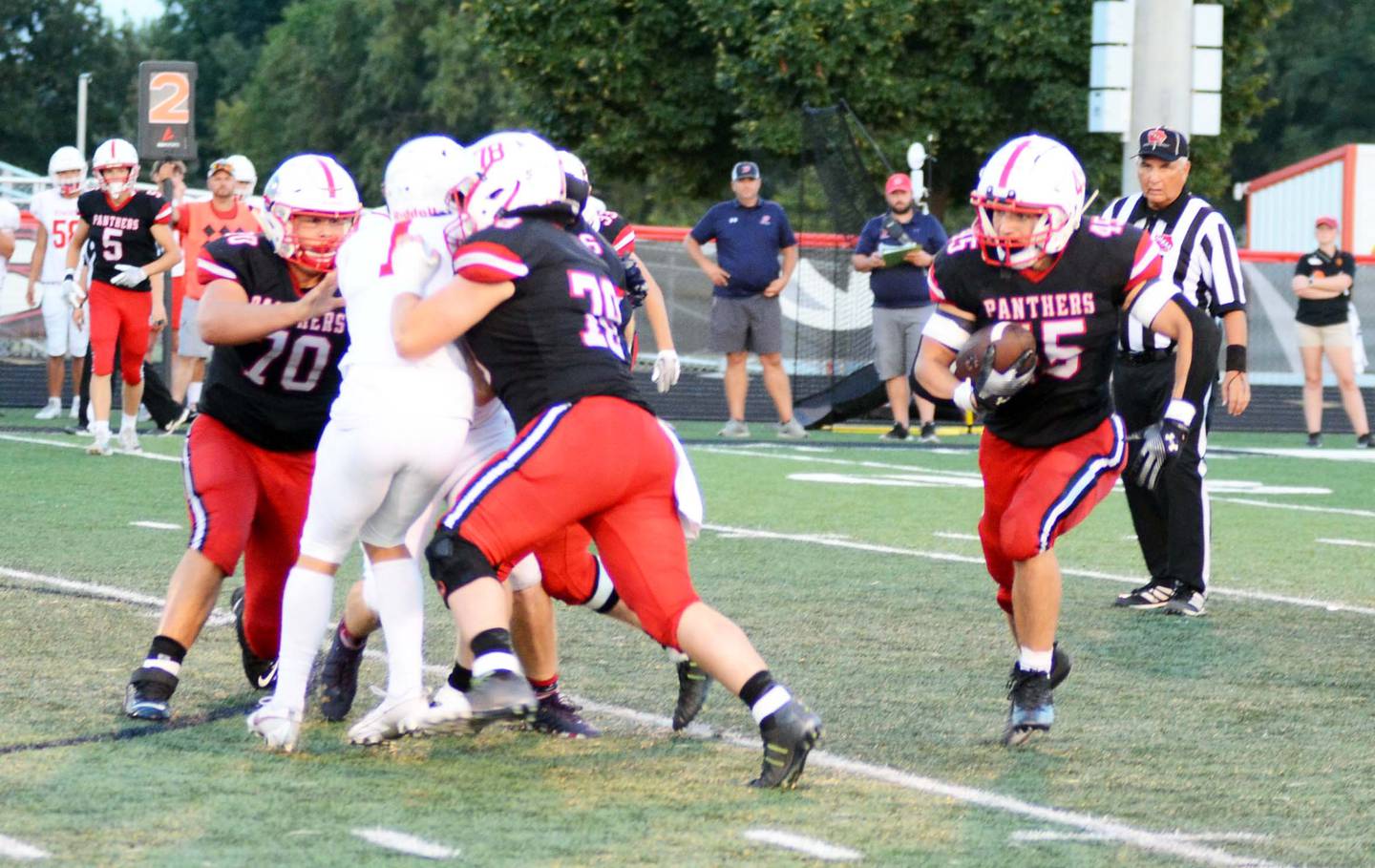 Offensive linemen Quinten Fuller, left, and Jagger Luther, center, block a Ballard defensive player from getting to running back Brennan Hayes.