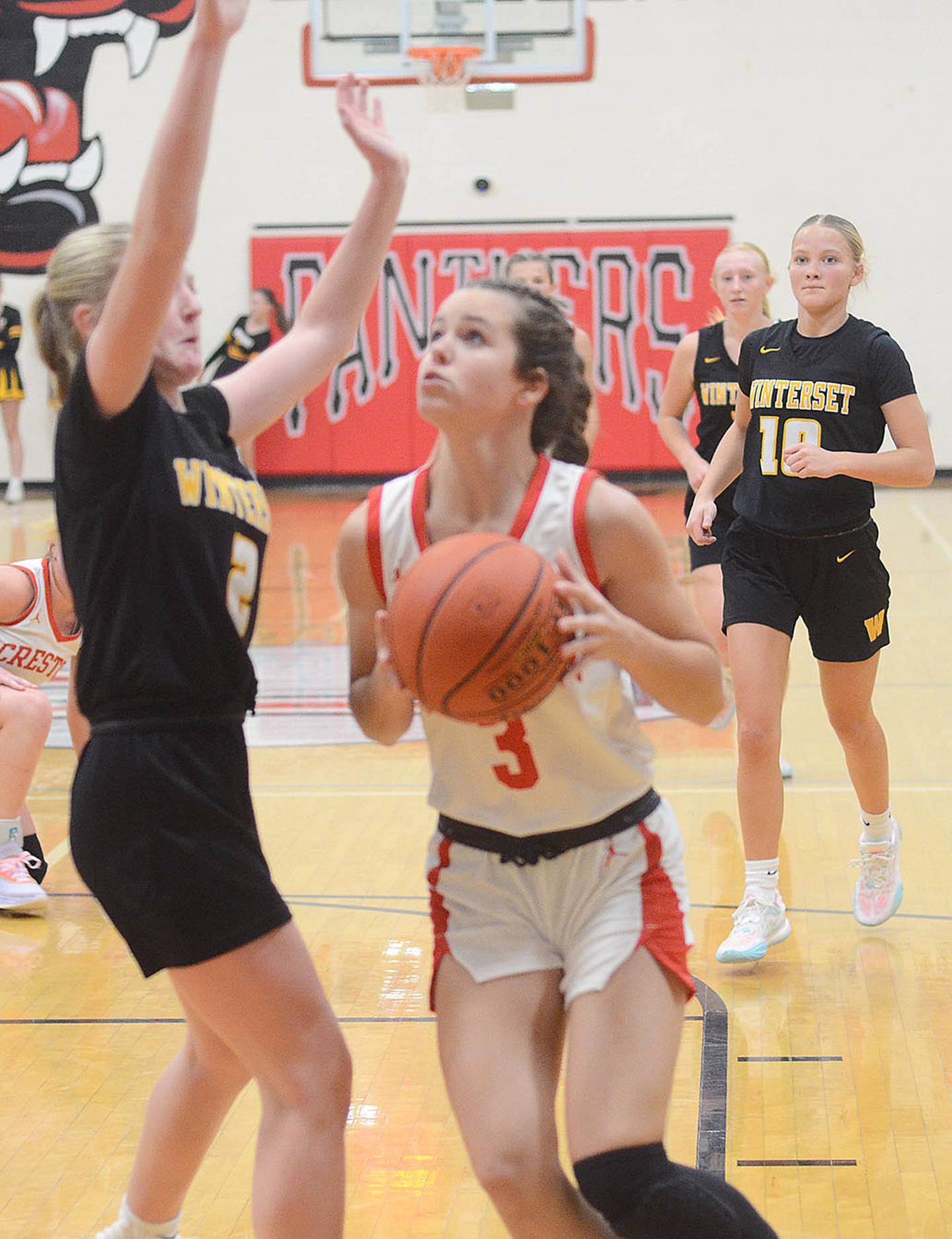 Braylee Pokorny of Creston drives against Winterset defender Makenna Olson. Pokorny scored two points in the 55-40 loss.