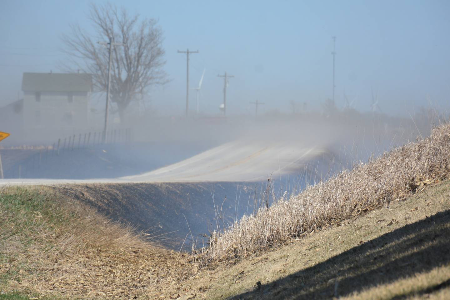 Heavy smoke crosses 310th Street west of Orient, causing limited to no visibility for firefighters traversing the area trying to put a nearly 2-mile long wildfire out.