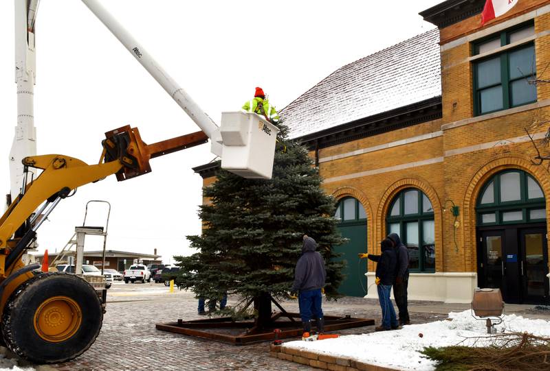 The Creston Street Department and community volunteers work together to put up a Christmas tree in front of the restored depot. This year's tree was donated by Chad and Amy Rieck and Kyle and Ashley Weaver.